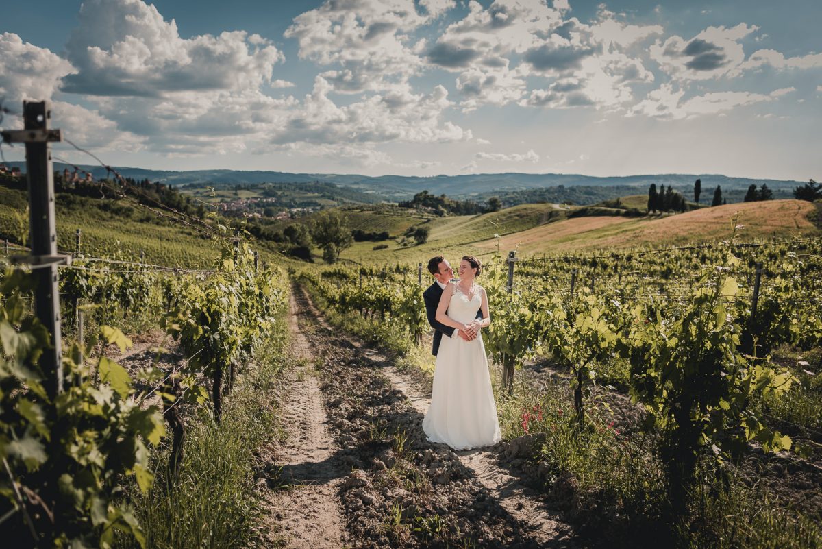 Couple hugging in a vineyard in Tuscany.