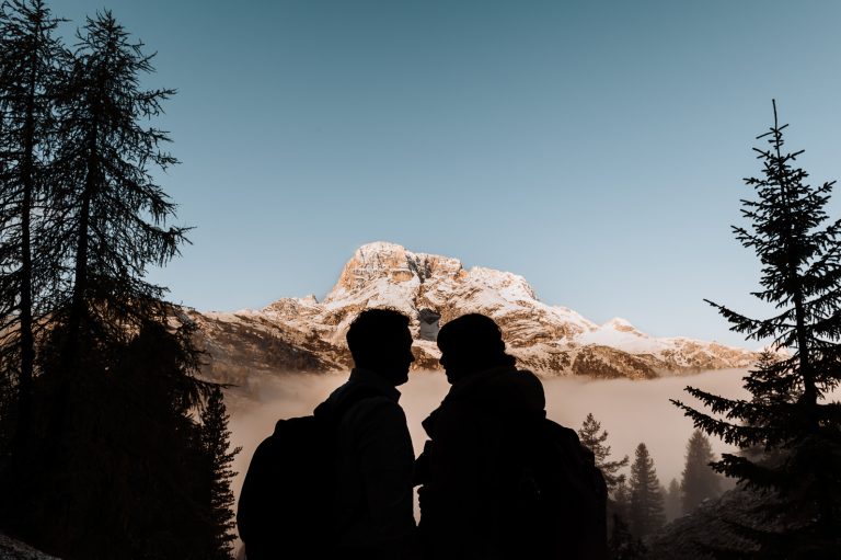 Couple standing close to each other in front of the mountains