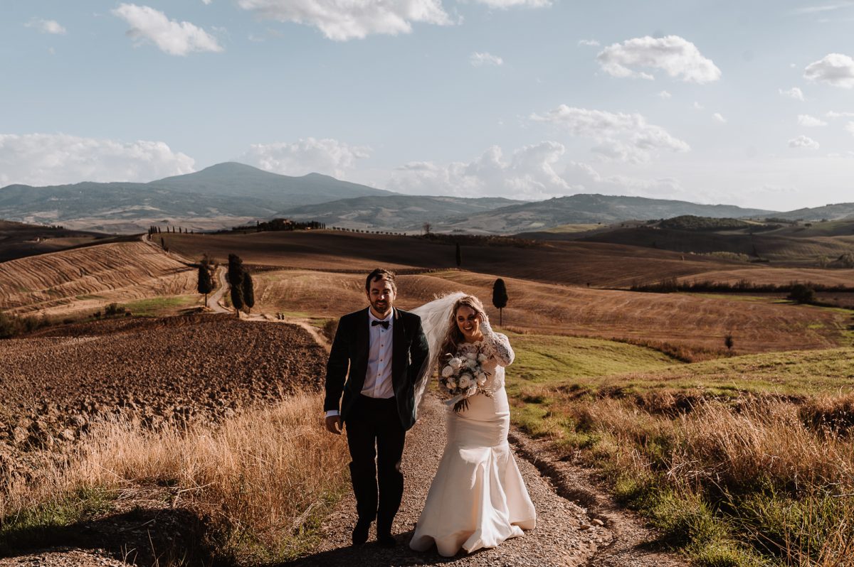 Couple walking on tuscan fields in Italy