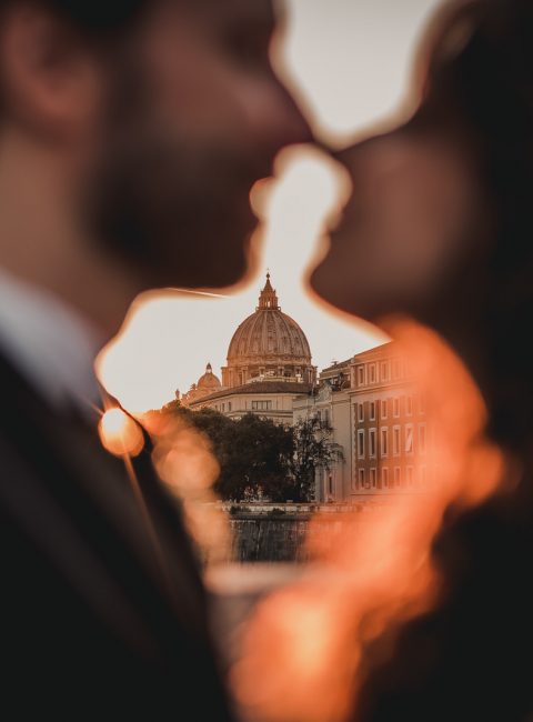 Photo showing a couple kissing with S. Peter Church in the background