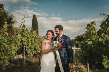 Couple walking through a vineyard in Rome. The bride has a boho wedding dress, with a delicate bouquet.